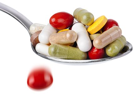 cucchiao pieno di pillole compresse e capsule colorate