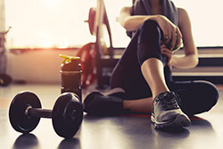 Foto di una donna in abiti allenamento che si estende dopo un allenamento in palestra