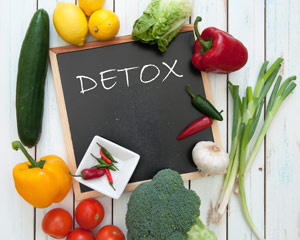 detox scritto su lavagna nera in mezzo a frutta e verdura fresca