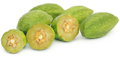 Frutti interi haritaki e pezzi di frutta haritaki su uno sfondo bianco Frutti interi haritaki e pezzi di frutta haritaki su uno sfondo bianco