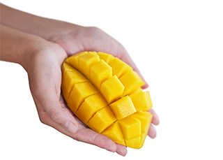 mani di donna che reggono un mango tagliato a cubetti