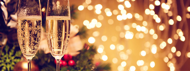 due bicchieri di champagne davanti alle luci di Natale