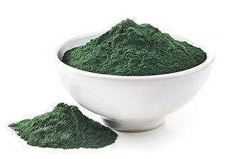ciotola bianca con polvere di spirulina verde su sfondo bianco
