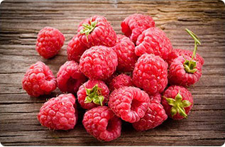 frutta fresca di lamponi rosa su tavola marrone vista dall'alto