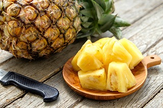 ananas tagliato a cubetti vicino a frutto ananas su tavola