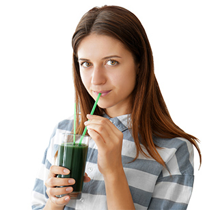 ragazza che beve un frullato verde a base di spirulina