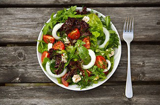 insalata fresca in ciotola bianca su tavola marrone