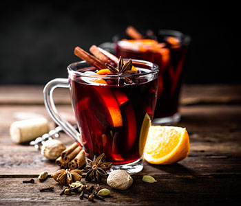 vino caldo in tazza trasparente con fruttas tagliata fresca e cannella